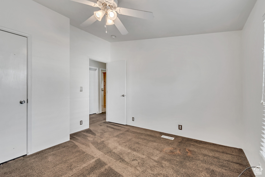 Unfurnished bedroom featuring visible vents, carpet flooring, ceiling fan, and vaulted ceiling