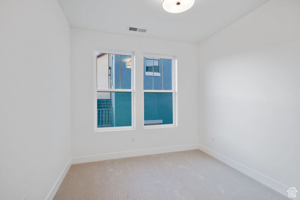 Unfurnished room featuring visible vents, carpet, and baseboards