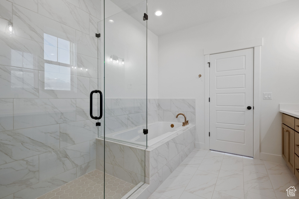 Full bath with vanity, marble finish floor, baseboards, a shower stall, and a garden tub