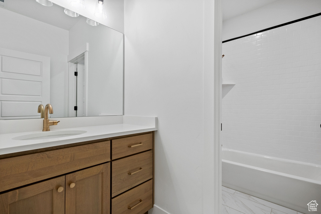 Bathroom featuring vanity, marble finish floor, and shower / tub combination