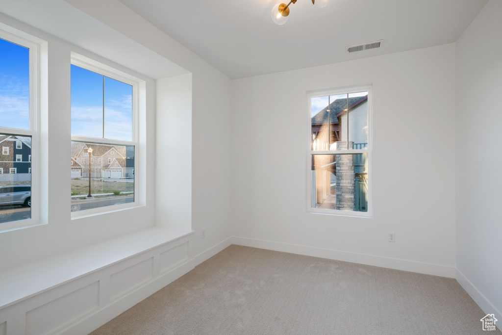 Empty room featuring visible vents and light carpet