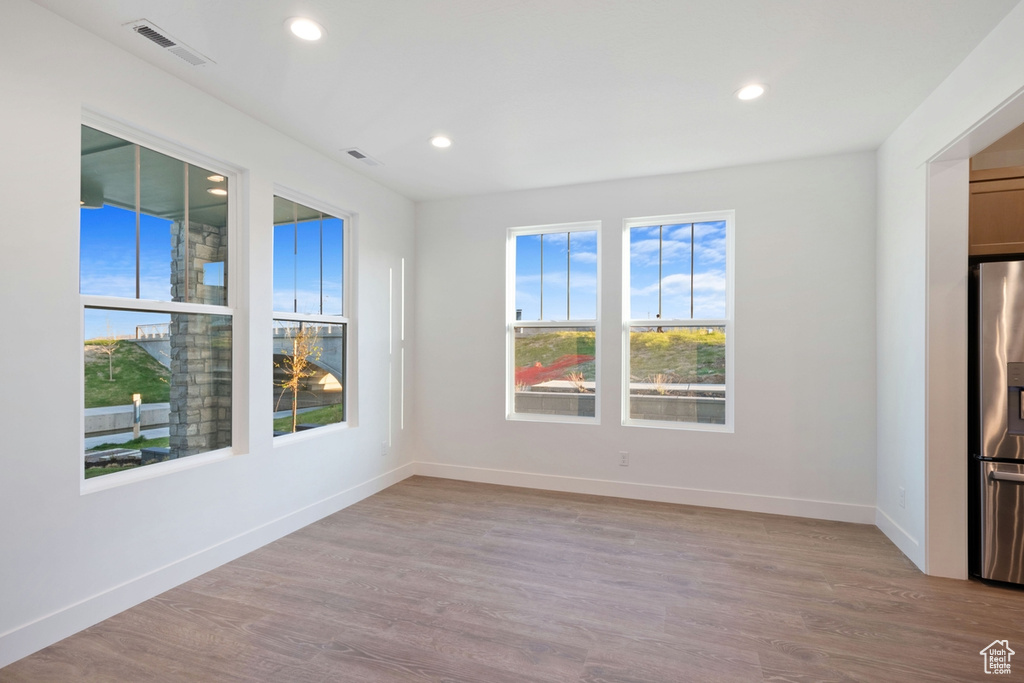 Empty room with recessed lighting, visible vents, and wood finished floors