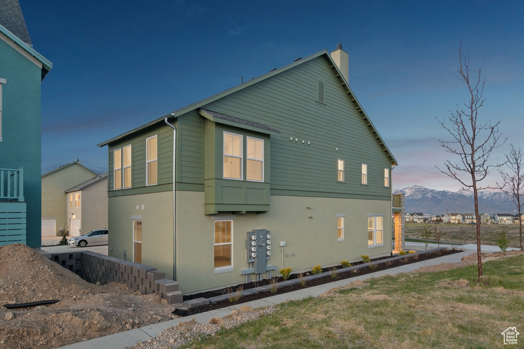 View of home's exterior featuring a chimney, a mountain view, and stucco siding