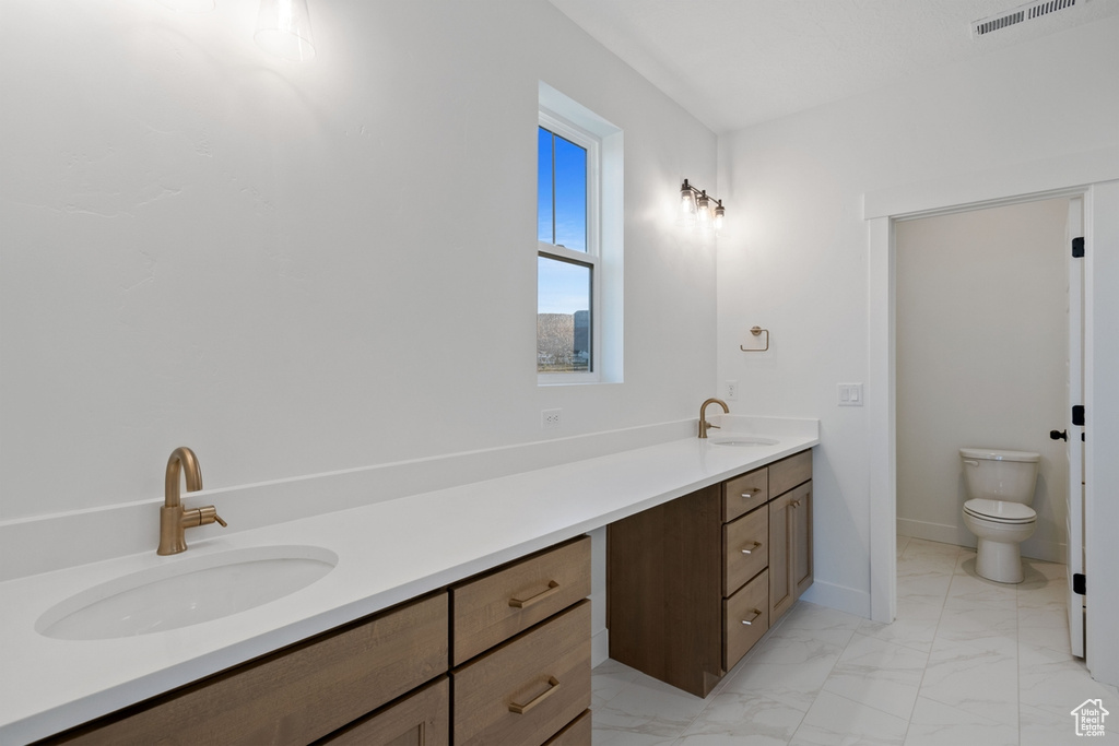 Full bath with vanity, visible vents, marble finish floor, toilet, and baseboards