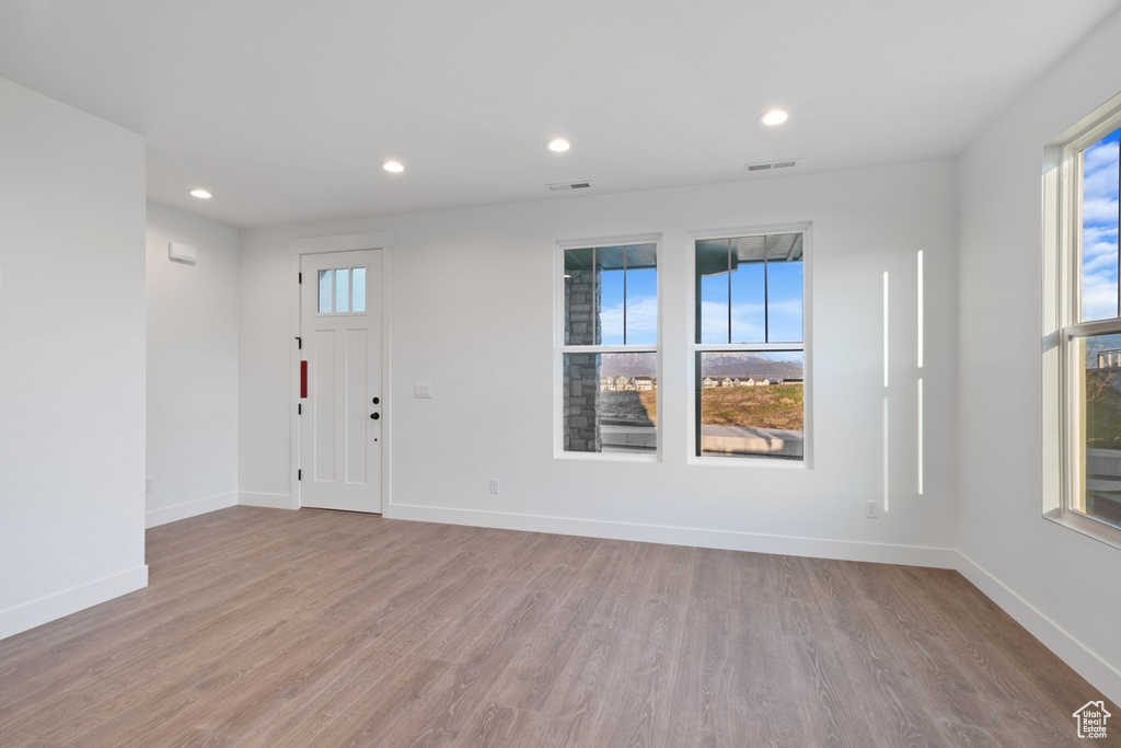 Interior space with baseboards, visible vents, plenty of natural light, and wood finished floors