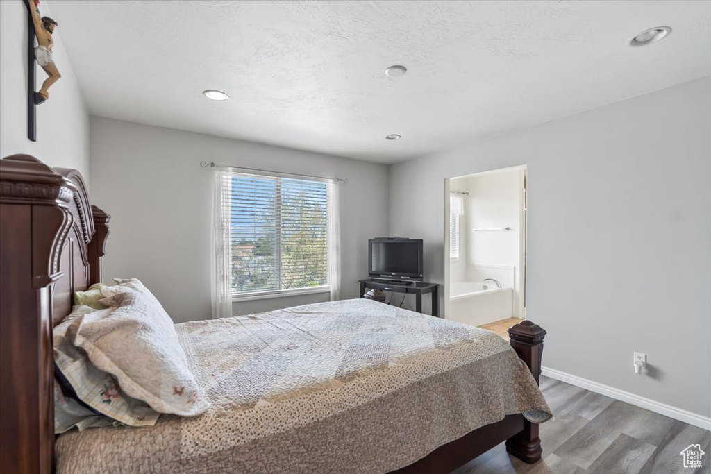 Bedroom featuring baseboards, recessed lighting, connected bathroom, and wood finished floors
