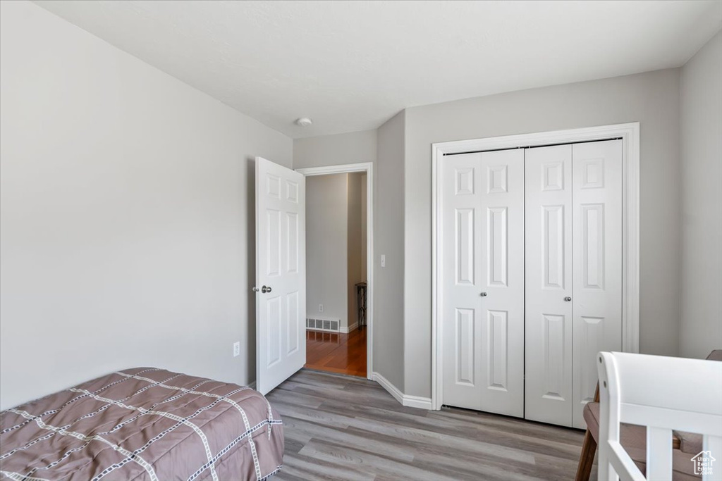 Bedroom featuring a closet, baseboards, visible vents, and light wood-style floors
