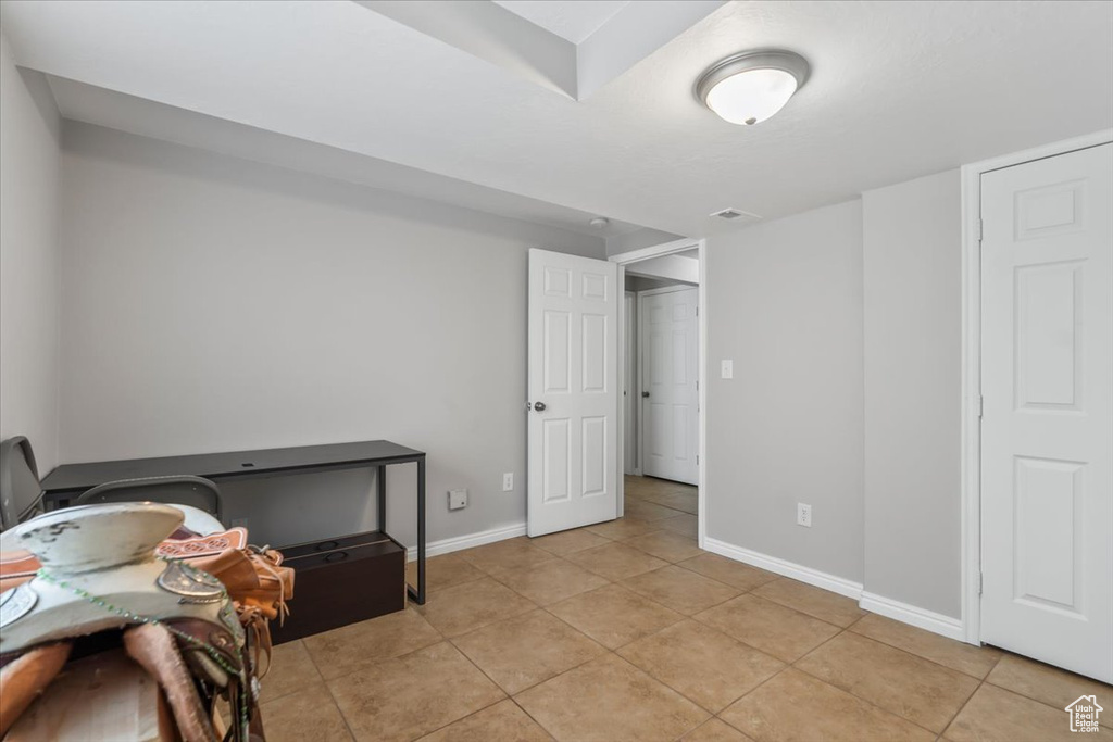 Basement featuring light tile patterned floors and baseboards