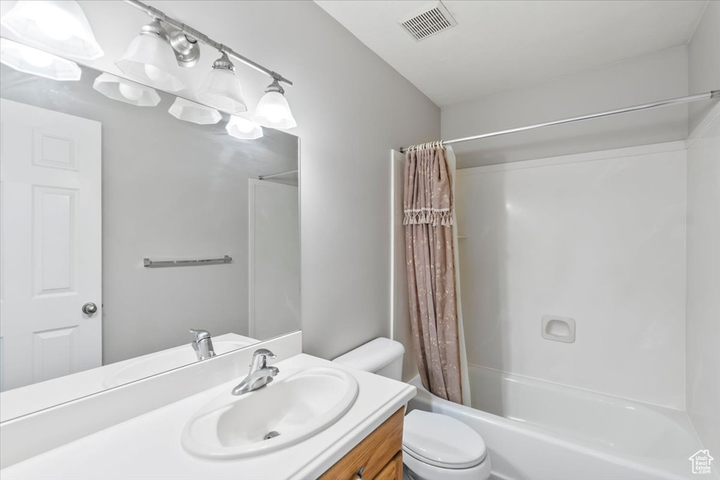 Full bath featuring vanity, shower / bath combo, toilet, and visible vents