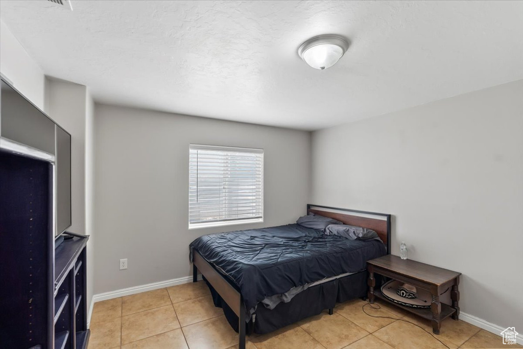Bedroom with baseboards and light tile patterned floors