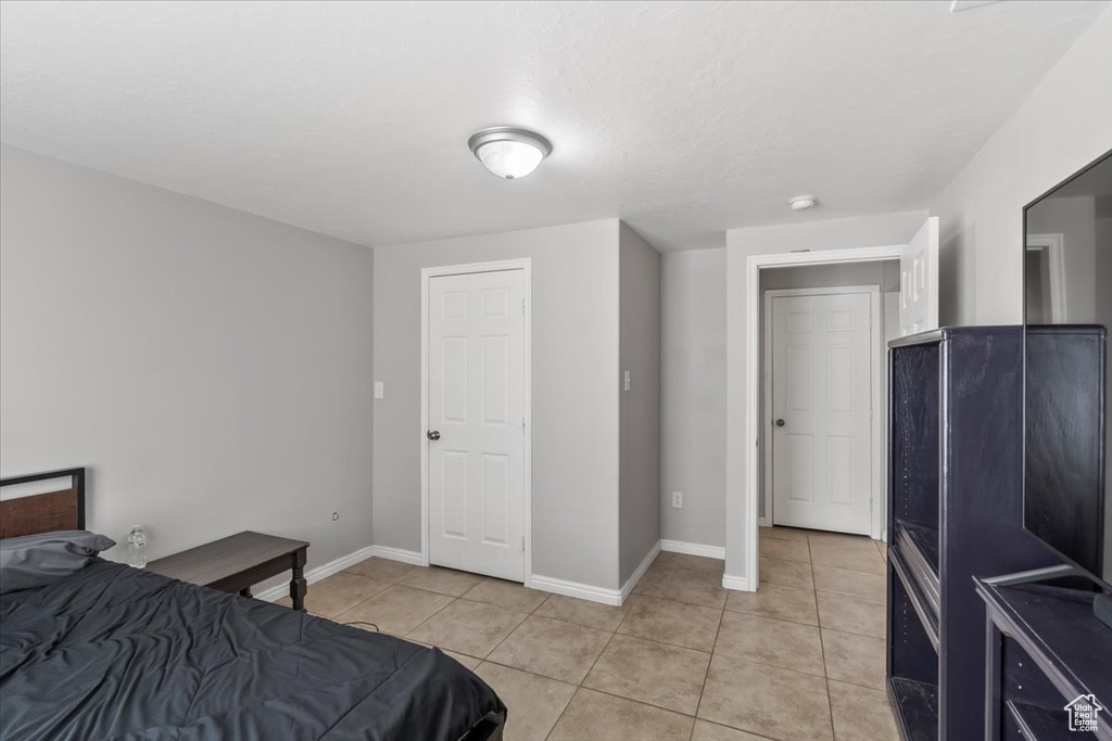 Bedroom featuring baseboards and light tile patterned floors
