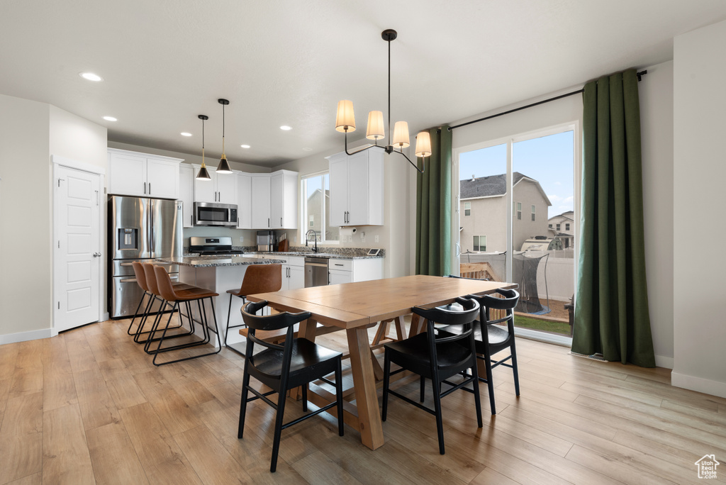 Dining space featuring light wood-style floors, recessed lighting, and baseboards