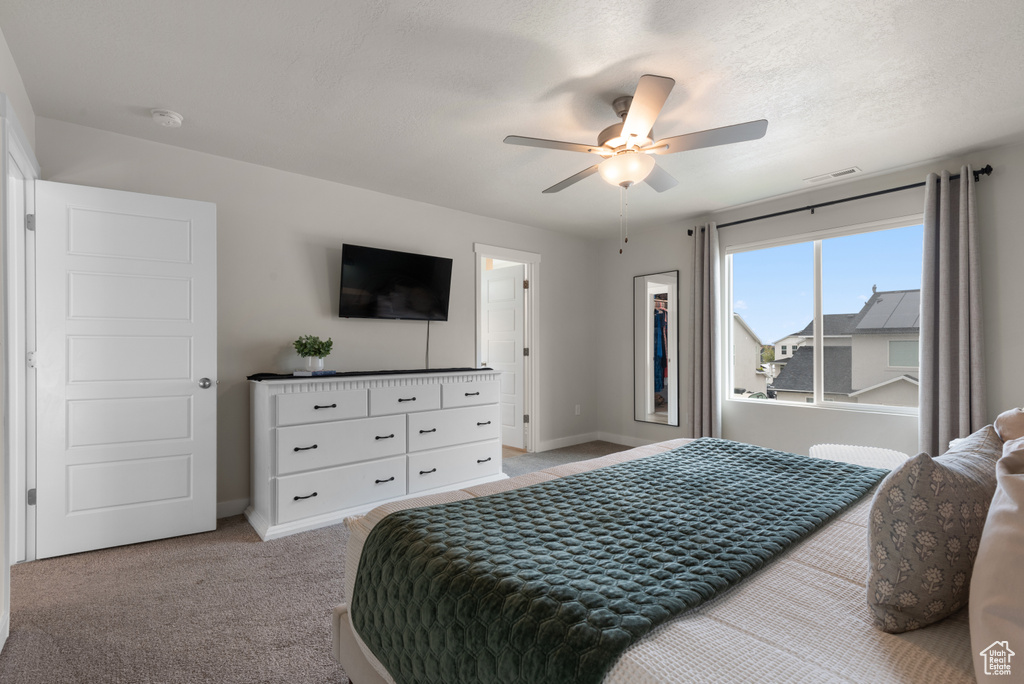 Bedroom featuring light colored carpet, baseboards, visible vents, and a ceiling fan