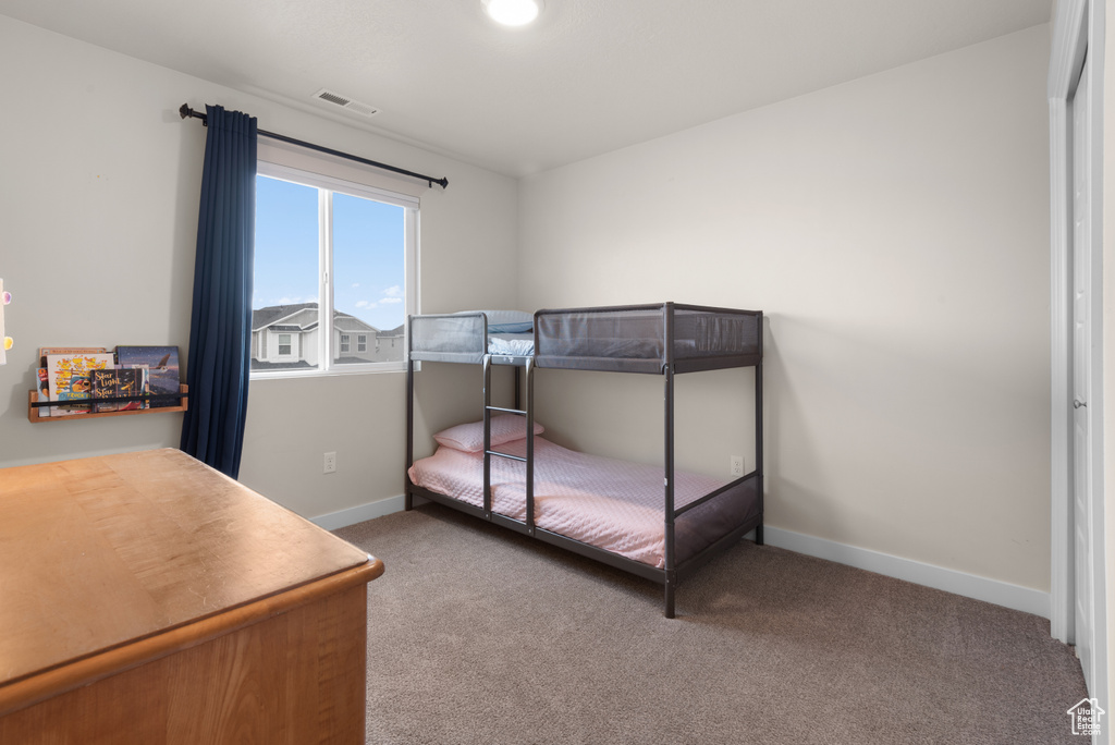Carpeted bedroom with baseboards and visible vents