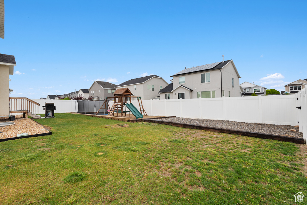 View of yard with a residential view, a fenced backyard, and a playground