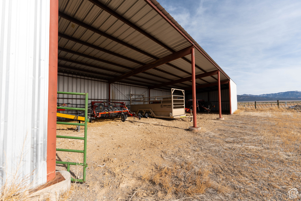 View of pole building featuring a detached carport, a mountain view, and an exterior structure