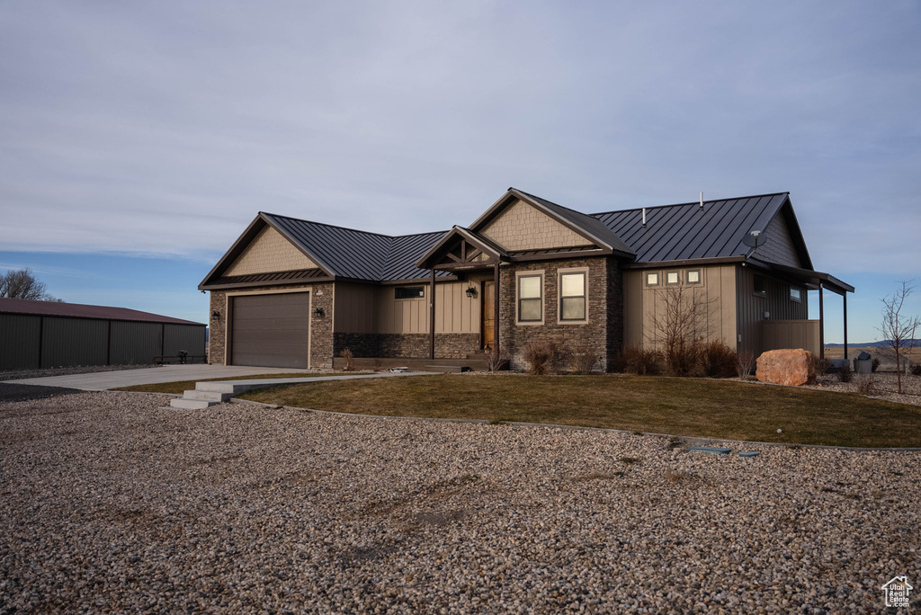 View of front of property featuring a standing seam roof, concrete driveway, and metal roof