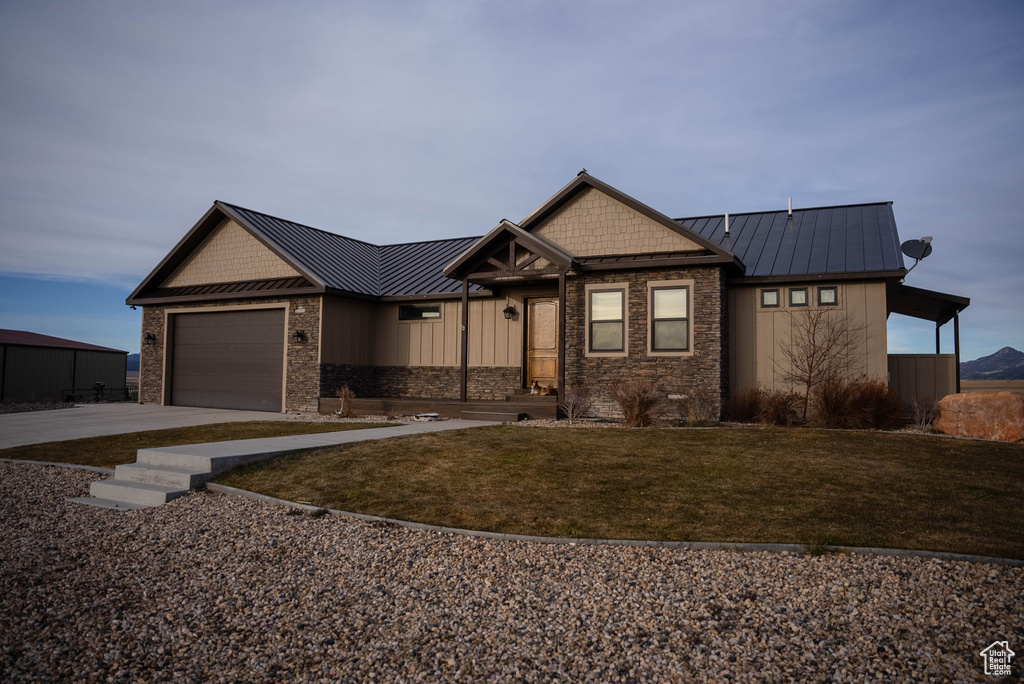 Craftsman-style home with a standing seam roof, driveway, and metal roof