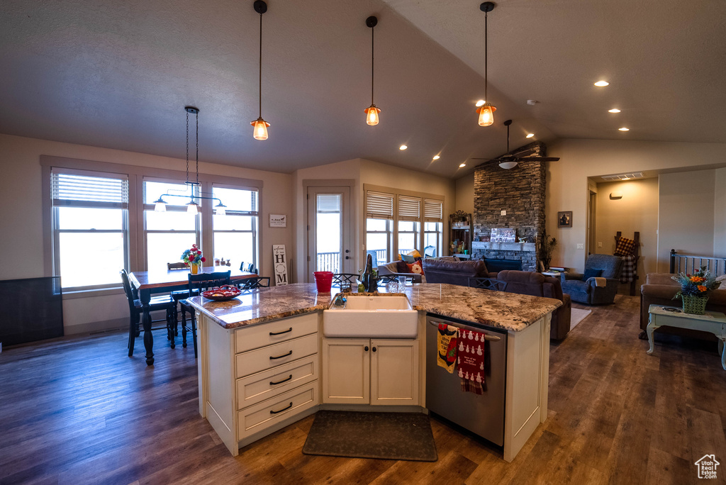 Kitchen featuring ceiling fan, a sink, open floor plan, lofted ceiling, and stainless steel dishwasher