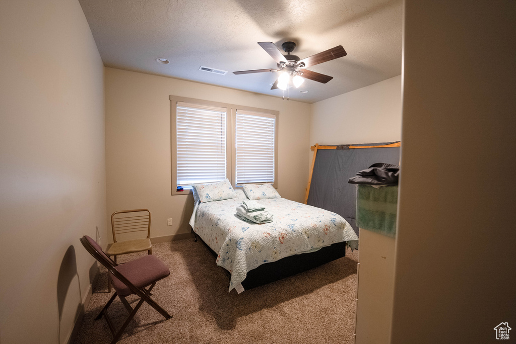 Bedroom with carpet floors, baseboards, a ceiling fan, and visible vents