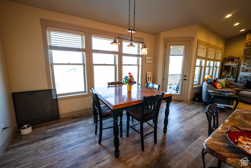 Dining area featuring baseboards, vaulted ceiling, recessed lighting, and wood finished floors