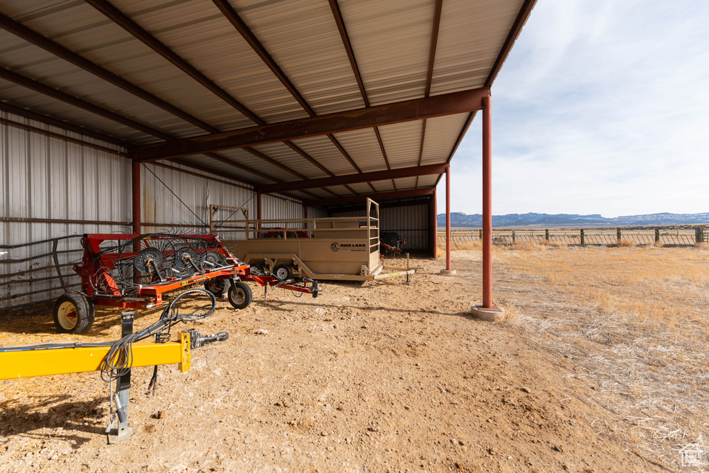 View of yard with an outbuilding, a carport, fence, a pole building, and a mountain view