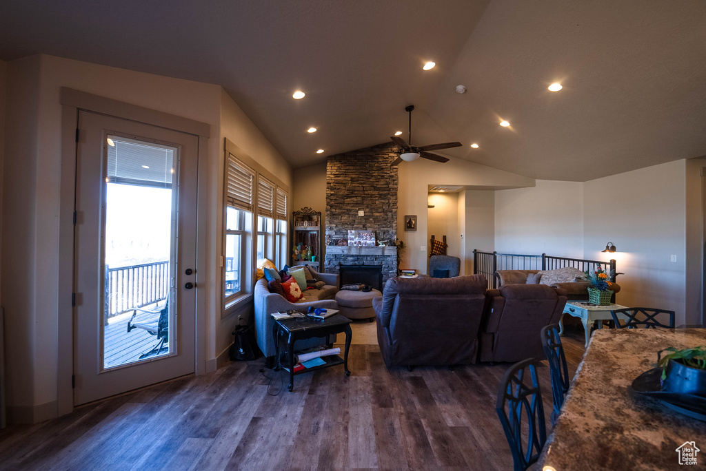 Living room featuring ceiling fan, a fireplace, vaulted ceiling, wood finished floors, and recessed lighting