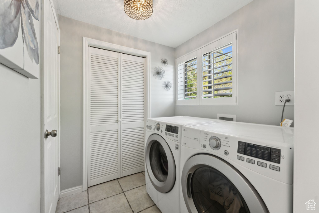 Laundry area featuring laundry area, baseboards, light tile patterned floors, and washer and dryer