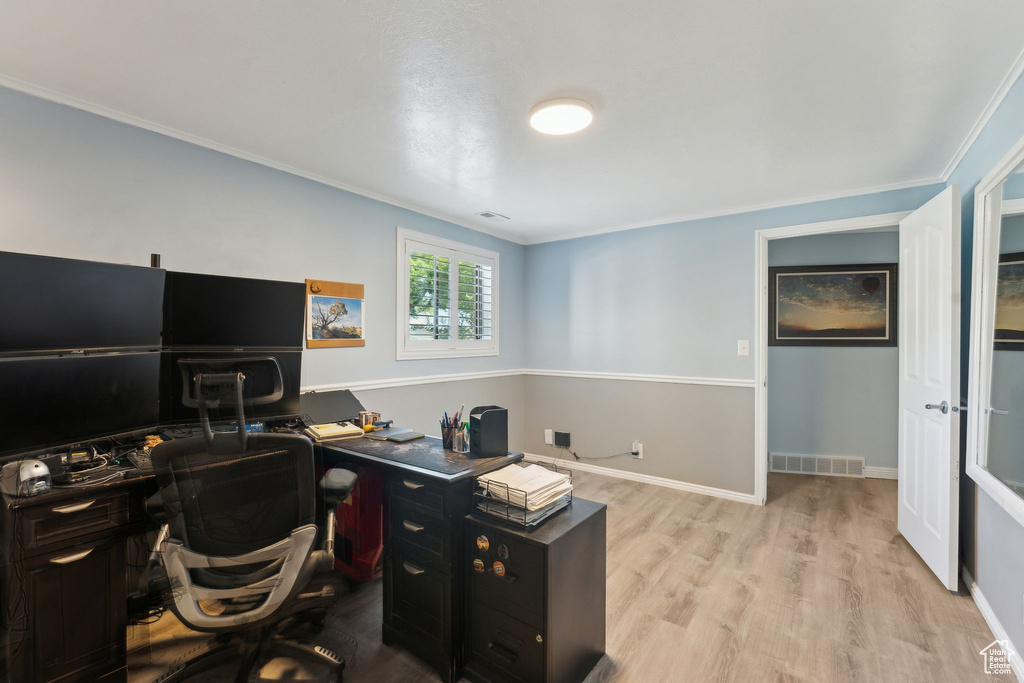 Office with visible vents, ornamental molding, baseboards, and wood finished floors