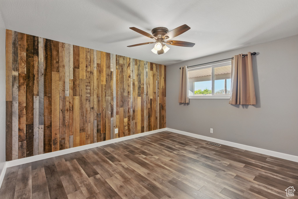 Spare room with visible vents, baseboards, ceiling fan, and wood finished floors
