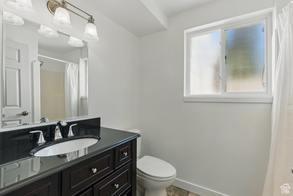 Full bath with vanity, toilet, and a shower with shower curtain