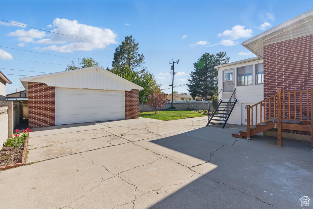 Exterior space featuring an outdoor structure, fence, and a detached garage