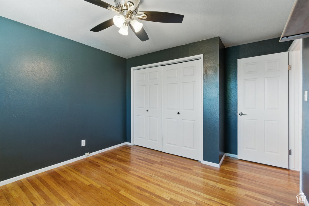 Unfurnished bedroom with a closet, baseboards, and light wood-type flooring