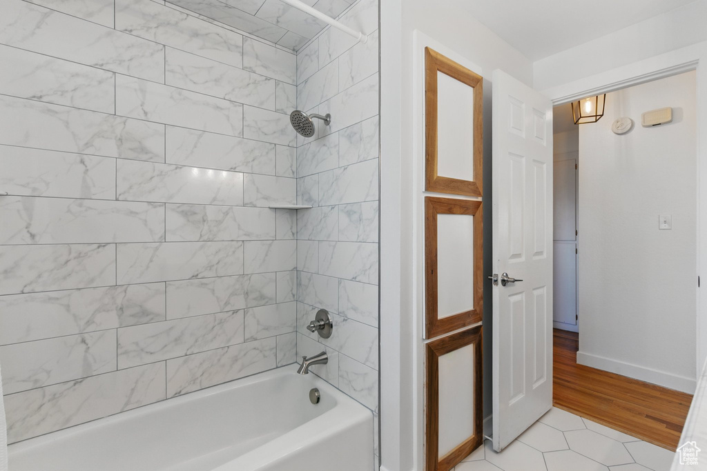 Bathroom with baseboards, washtub / shower combination, and tile patterned floors
