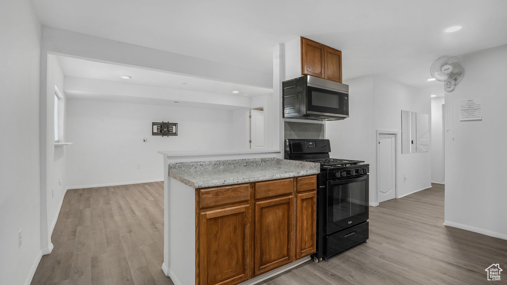 Kitchen featuring recessed lighting, light wood finished floors, black range with gas stovetop, and baseboards