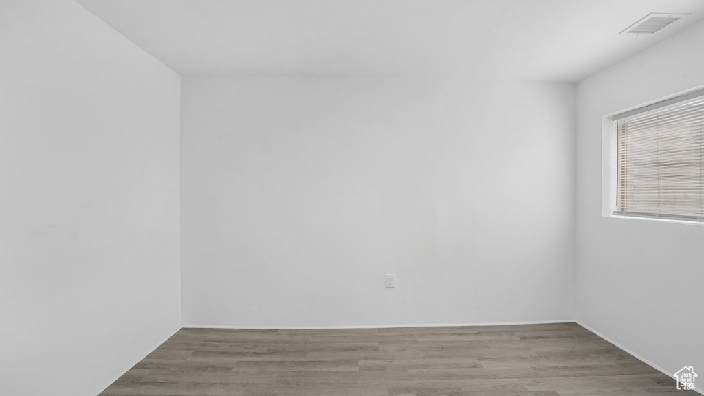 Empty room featuring wood finished floors and visible vents