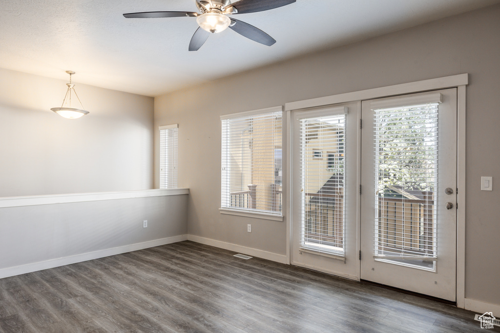 Empty room featuring baseboards, ceiling fan, wood finished floors, and visible vents