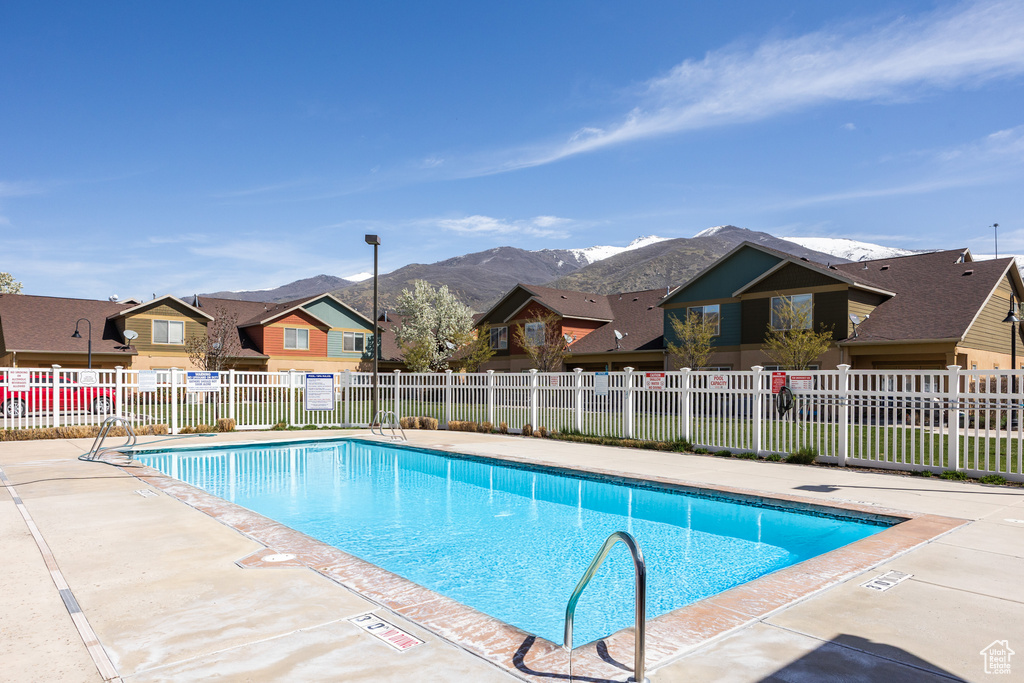 Pool featuring fence, a residential view, a mountain view, and a patio area