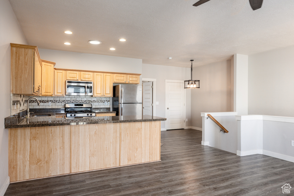 Kitchen with a sink, light brown cabinets, stainless steel appliances, a peninsula, and recessed lighting