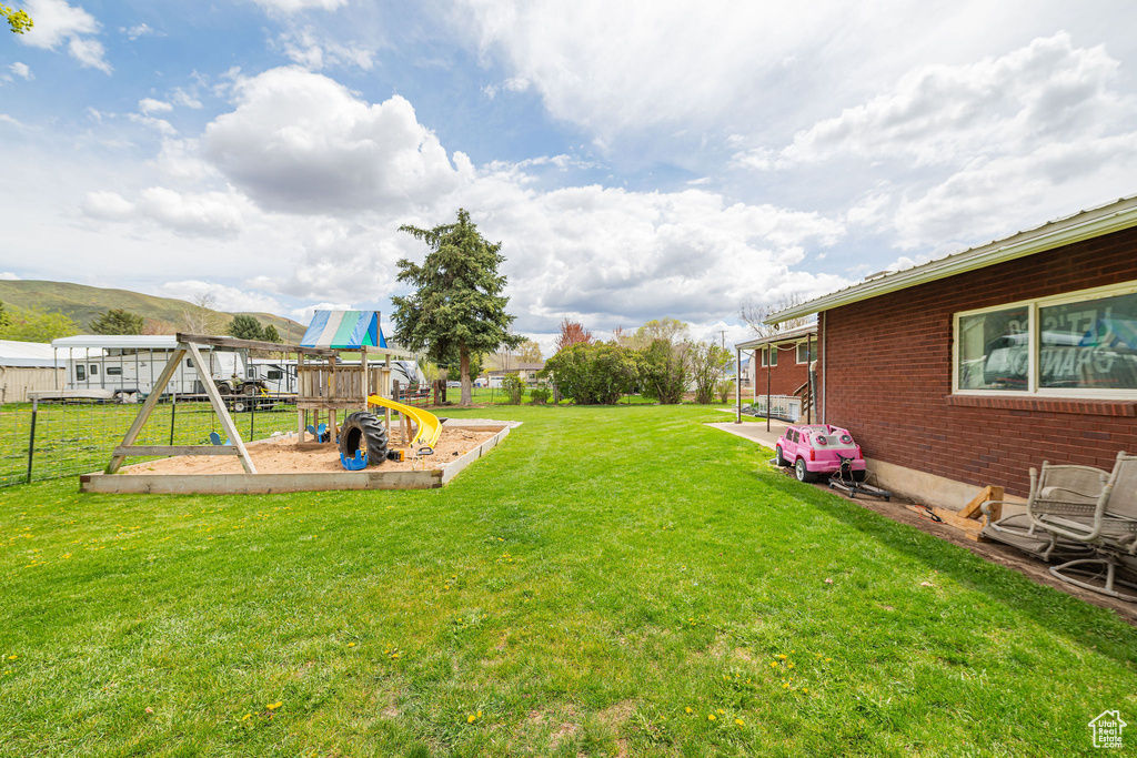 View of yard featuring a playground and fence