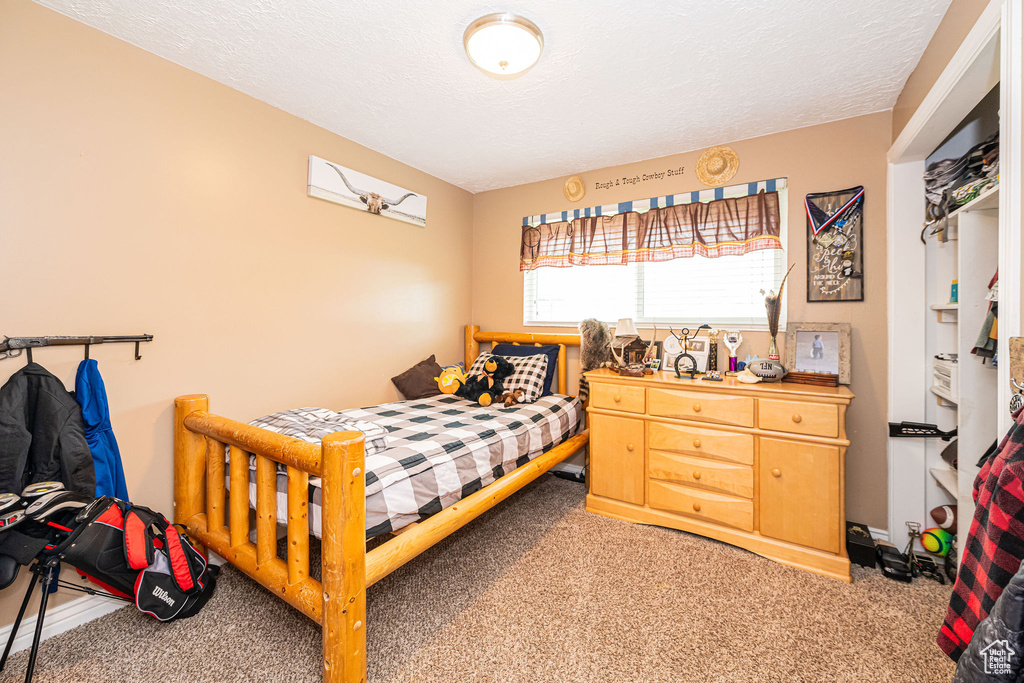 Carpeted bedroom featuring a textured ceiling