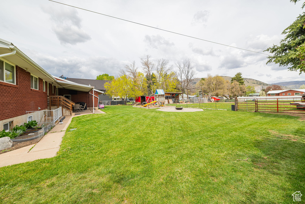 View of yard featuring a playground and fence