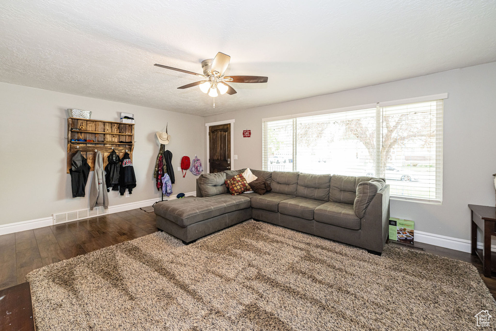 Living area featuring baseboards, ceiling fan, and wood finished floors