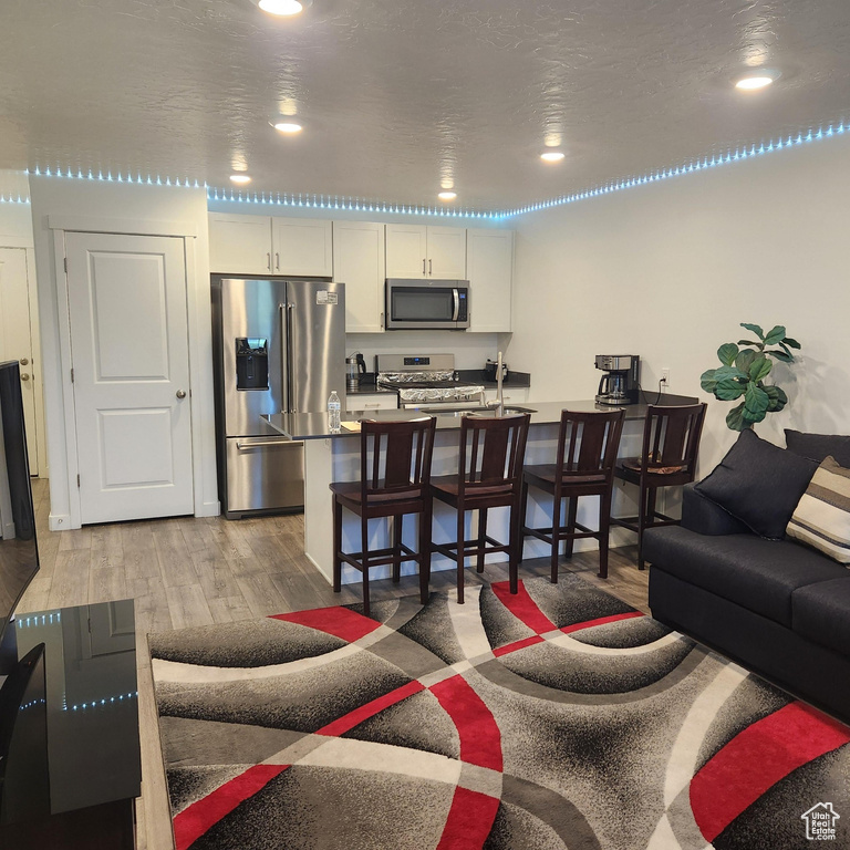 Living room with recessed lighting and light wood-type flooring