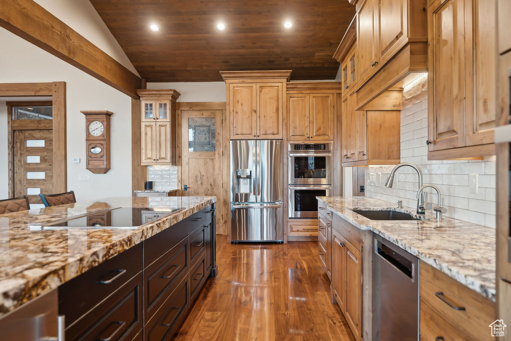 Kitchen featuring light stone countertops, recessed lighting, stainless steel appliances, dark wood-style flooring, and a sink