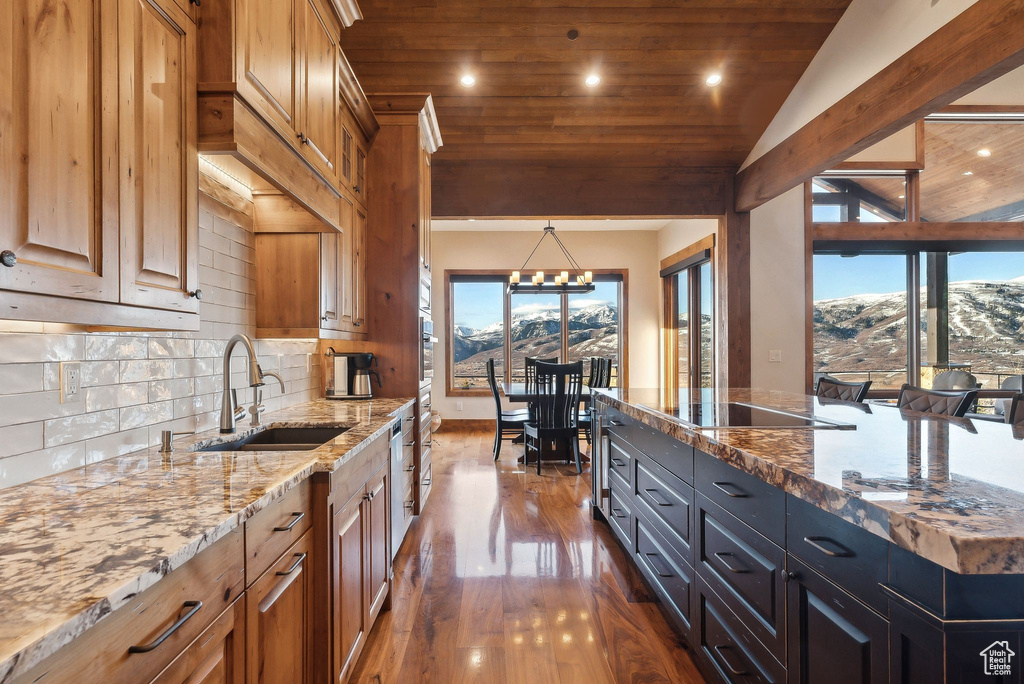 Kitchen with black electric stovetop, a sink, wooden ceiling, dark wood-style flooring, and backsplash