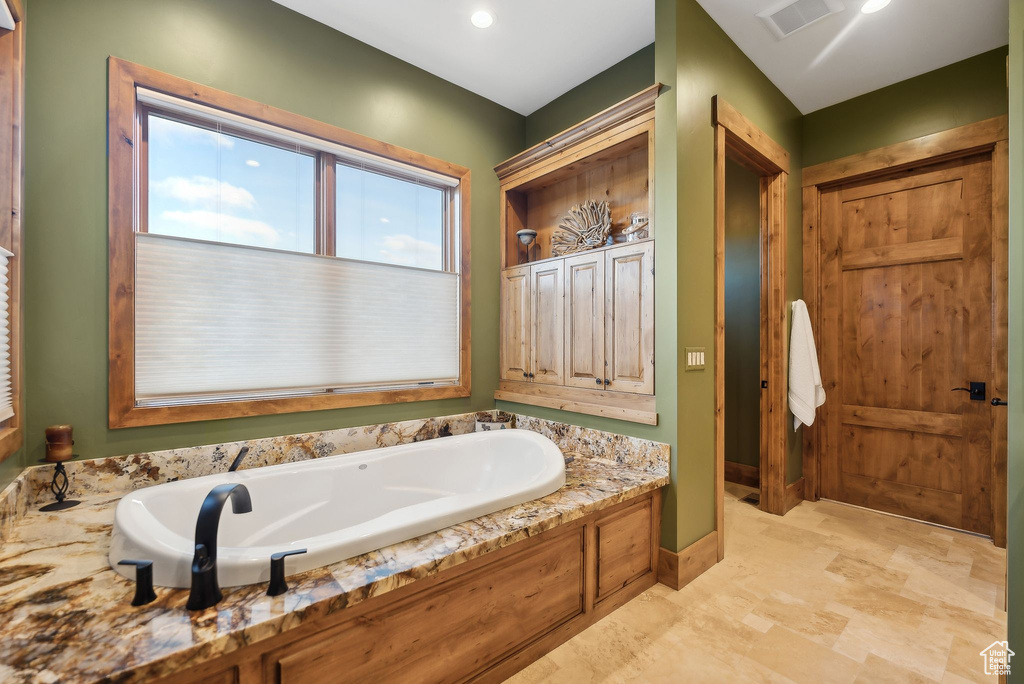 Full bath featuring a garden tub and visible vents