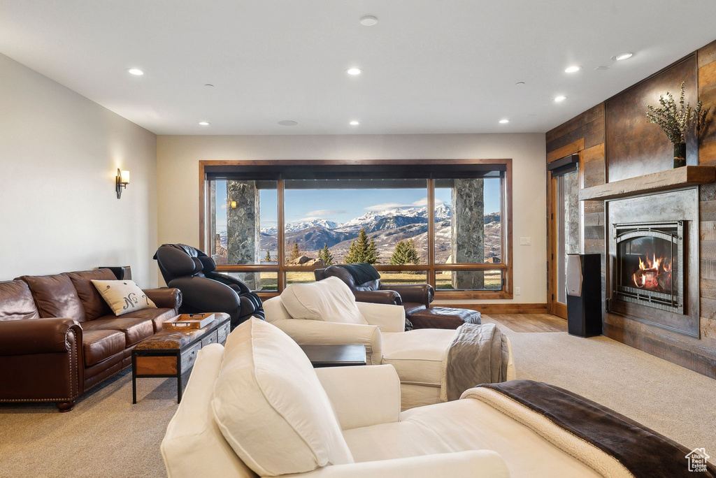 Living room featuring a glass covered fireplace, a mountain view, recessed lighting, and light carpet