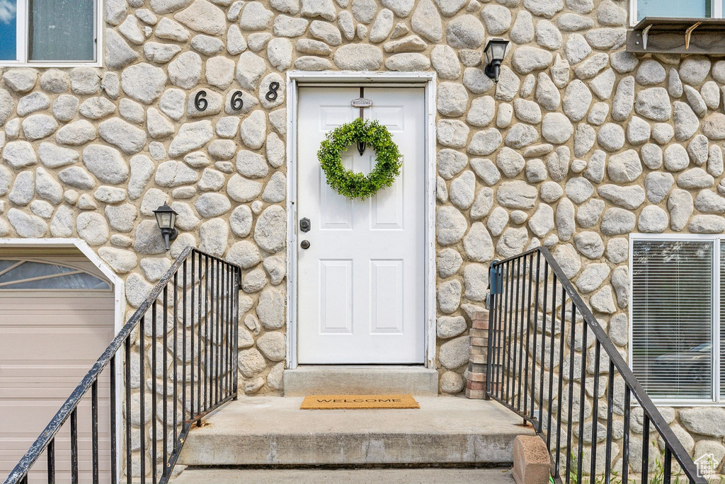 Entrance to property featuring stone siding