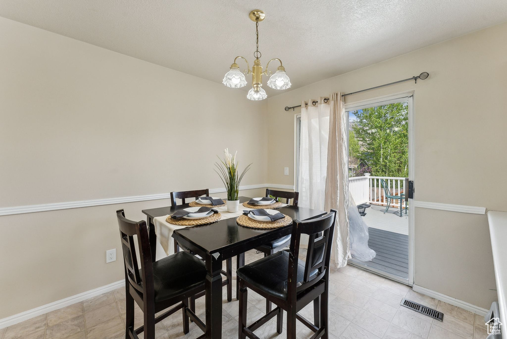Dining space featuring a chandelier, baseboards, and visible vents